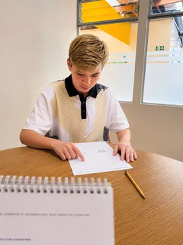 Adolescente resuelve un ejercicio de razonamiento en la mesa de evaluación.